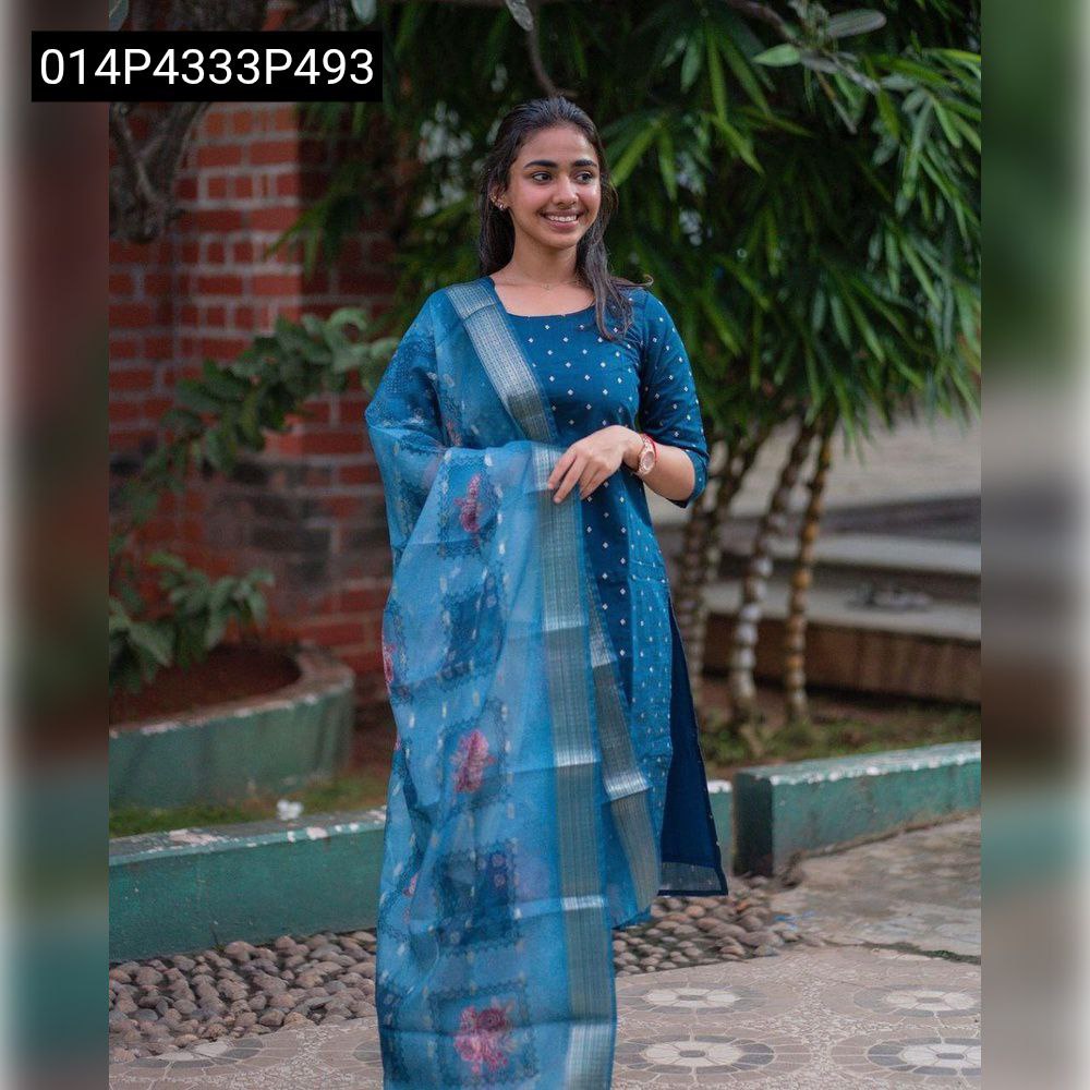 Full body shot of a smiling model in a deep teal blue Mal Cotton kurti with golden motifs and a gracefully draped Tissue Chanderi dupatta, standing outdoors.