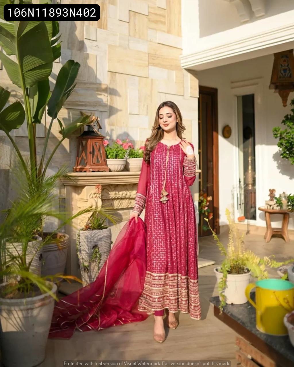 Model gracefully posing in TRENDBUY Fuchsia Red Anarkali Kurta Set with dupatta, outdoors in a garden setting.