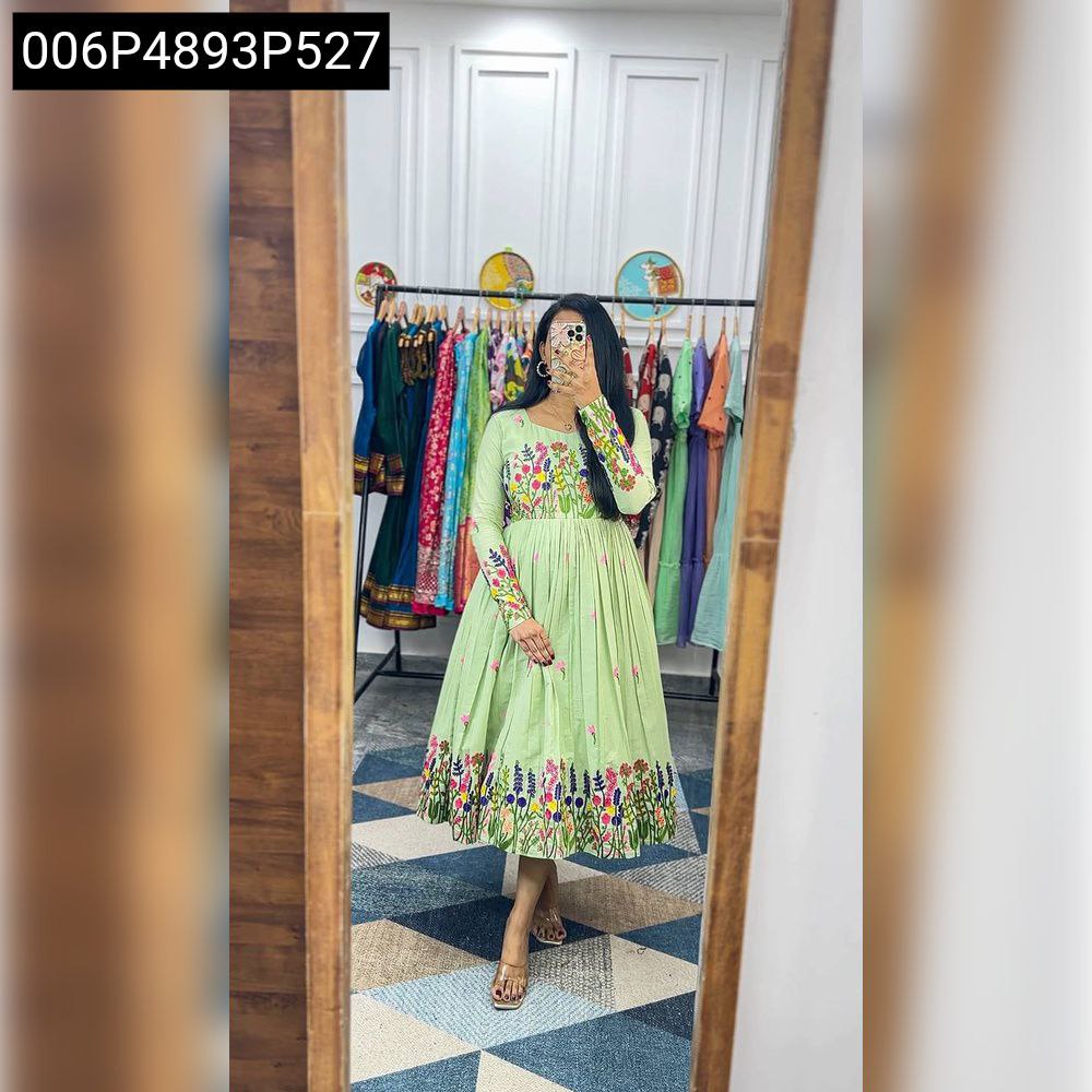 Full body shot of model wearing TRENDBUY light green Maska Cotton dress with vibrant floral chain stitch embroidery in a modern setting.