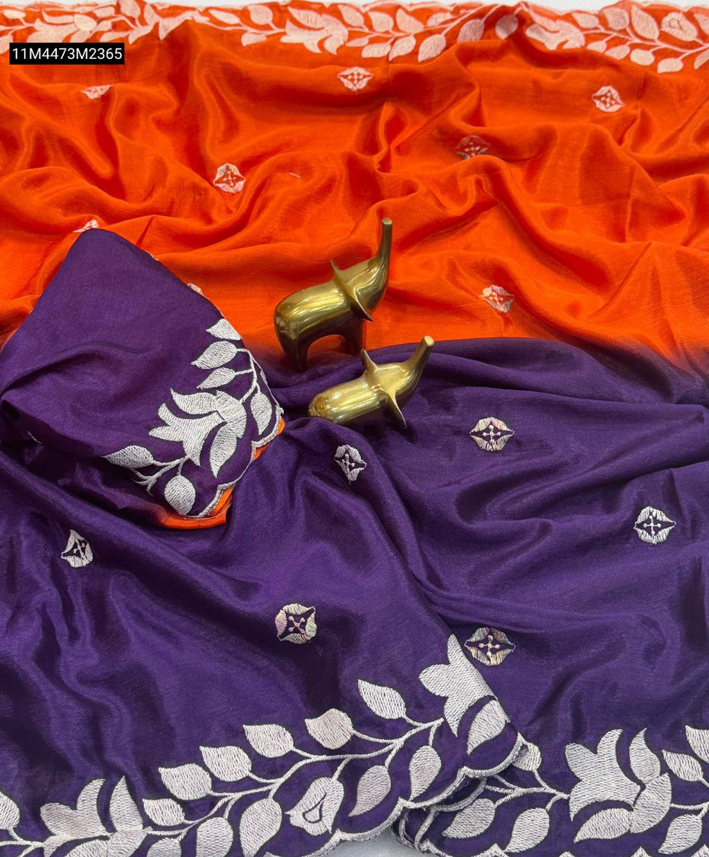 TRENDBUY Orange and Purple dual tone Chinon silk saree with white leaf embroidery on border, folded with matching embroidered blouse and brass elephant decor.