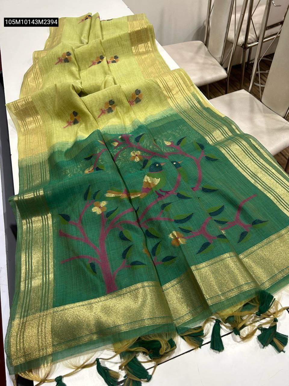 TRENDBUY Light Green Muga Cotton Saree with dark green resham Jamdani pallu featuring tree design and golden zari border, laid flat.