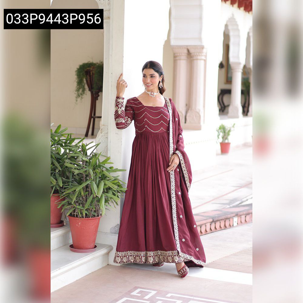 Woman in an elegant Wine Red Vichitra Silk Anarkali Gown with sequins, posing gracefully.