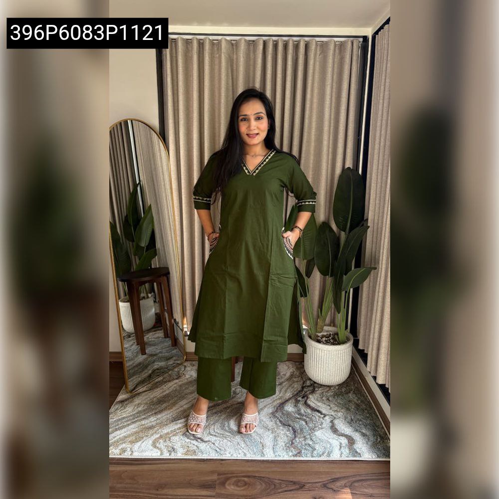Woman posing in olive green A-line kurti with pant set, featuring V-neck and decorative trim.