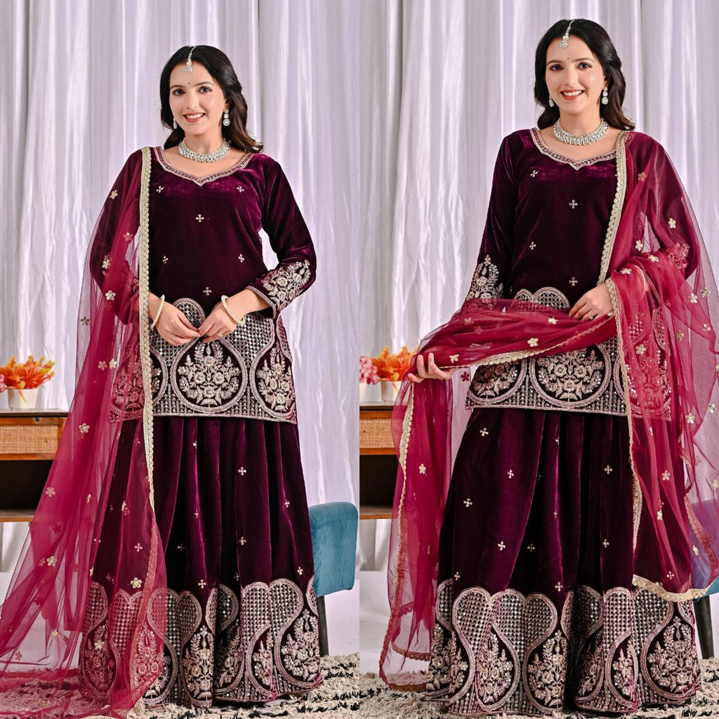 Woman posing in full shot wearing Deep Plum Viscous Velvet Sharara Suit with embroidery and net dupatta