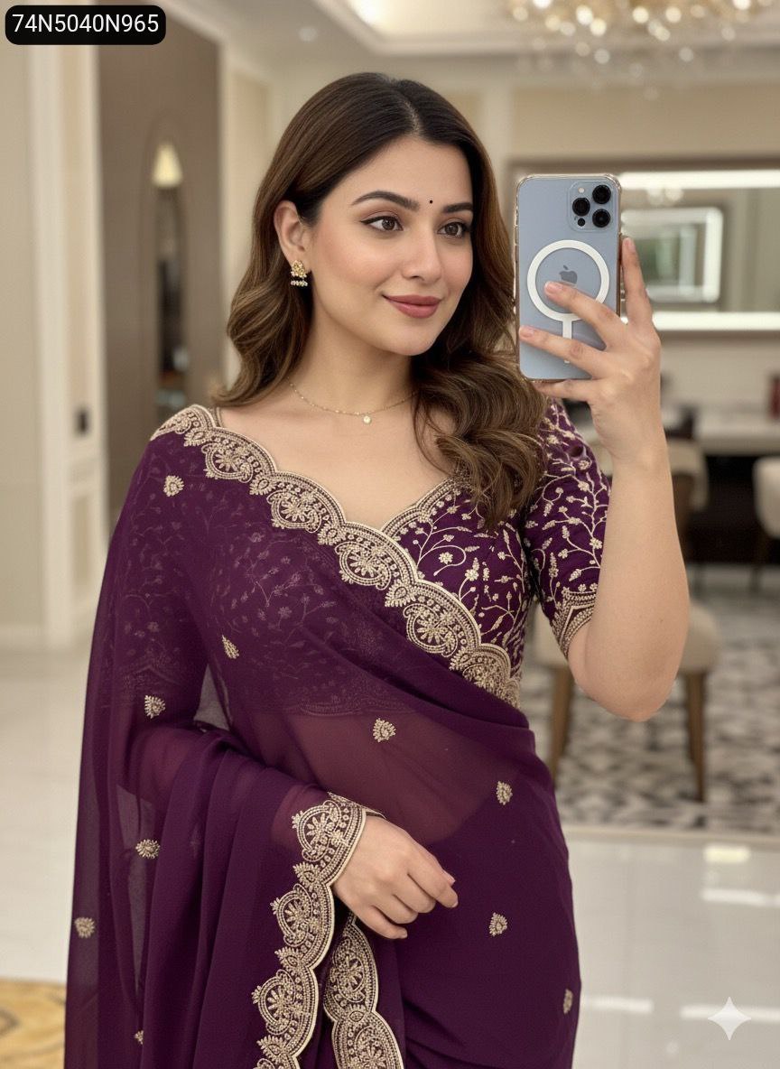 Model wearing a deep purple embroidered georgette saree with matching blouse, taking a mirror selfie.