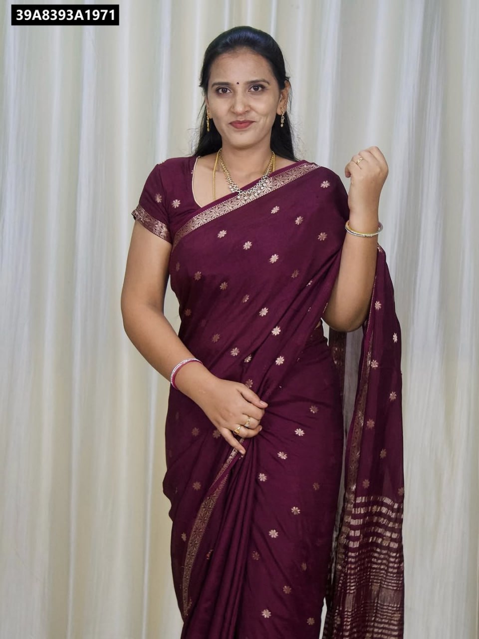 Woman posing in a beautiful Burgundy Pure Viscose Jacquard Saree with golden floral motifs and border, with a matching blouse.