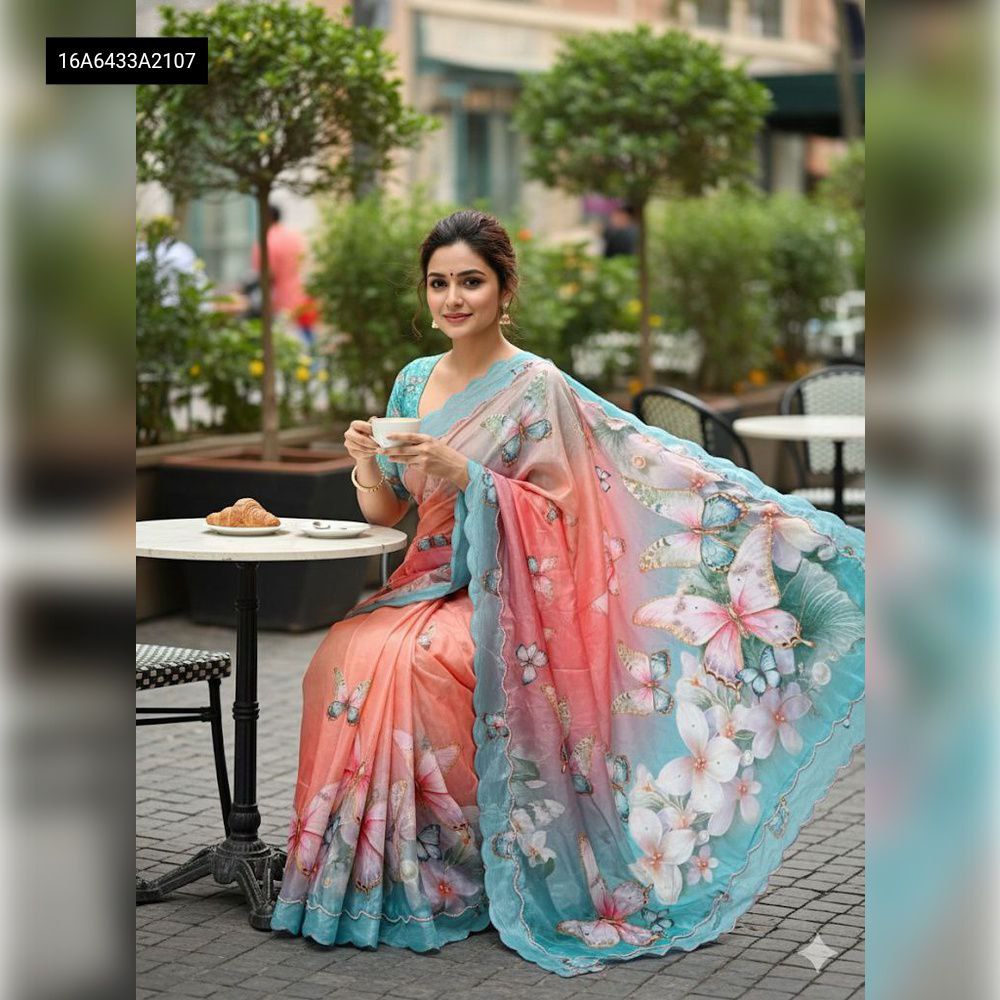 Model wearing TRENDBUY Digital Print Malai Silk Saree in Coral Teal Ombre with Butterfly design, sitting at cafe