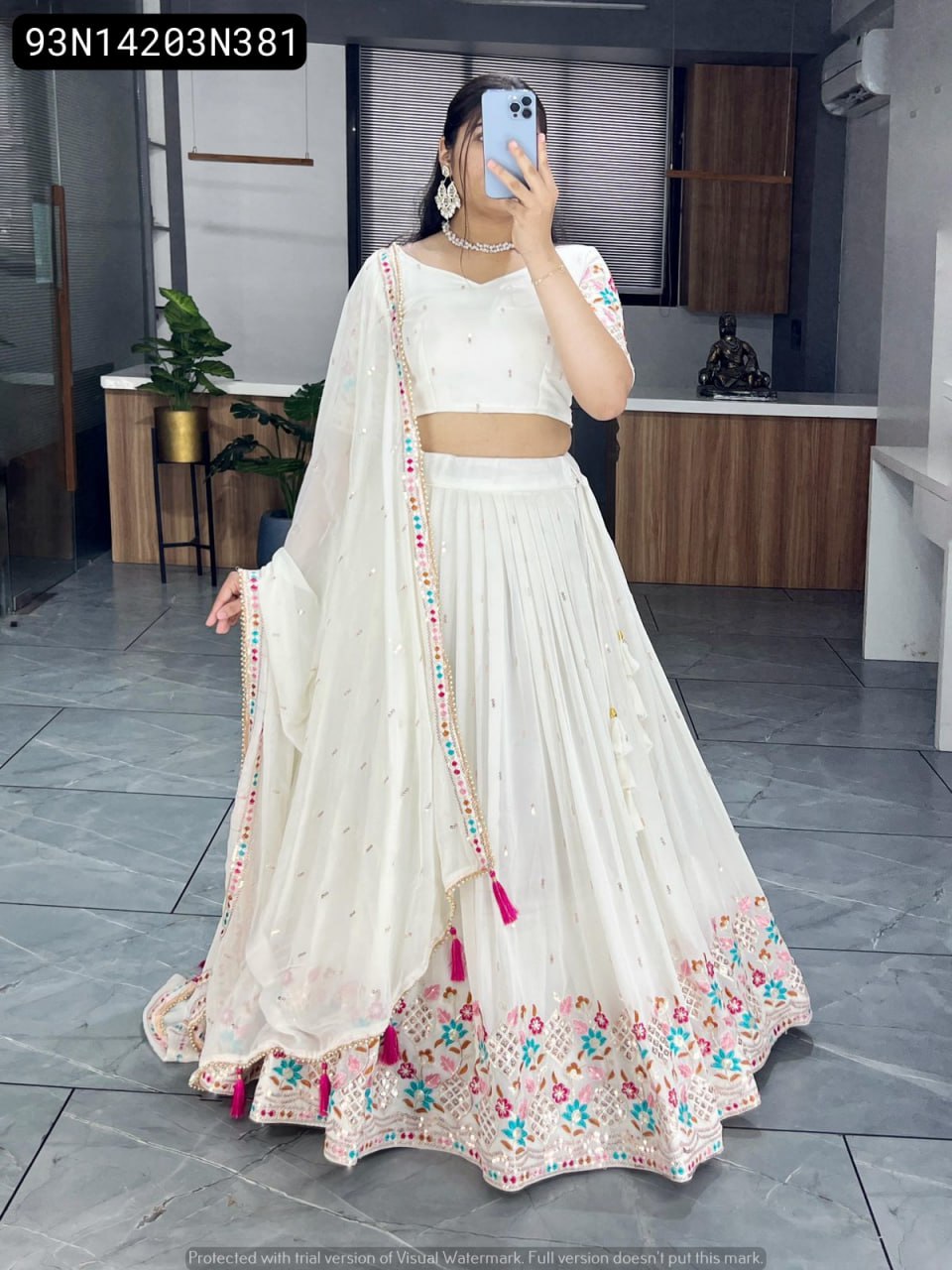 TRENDBUY White Faux Gorgette Lehenga Choli with multi-color embroidery and tassels, full body shot of model.