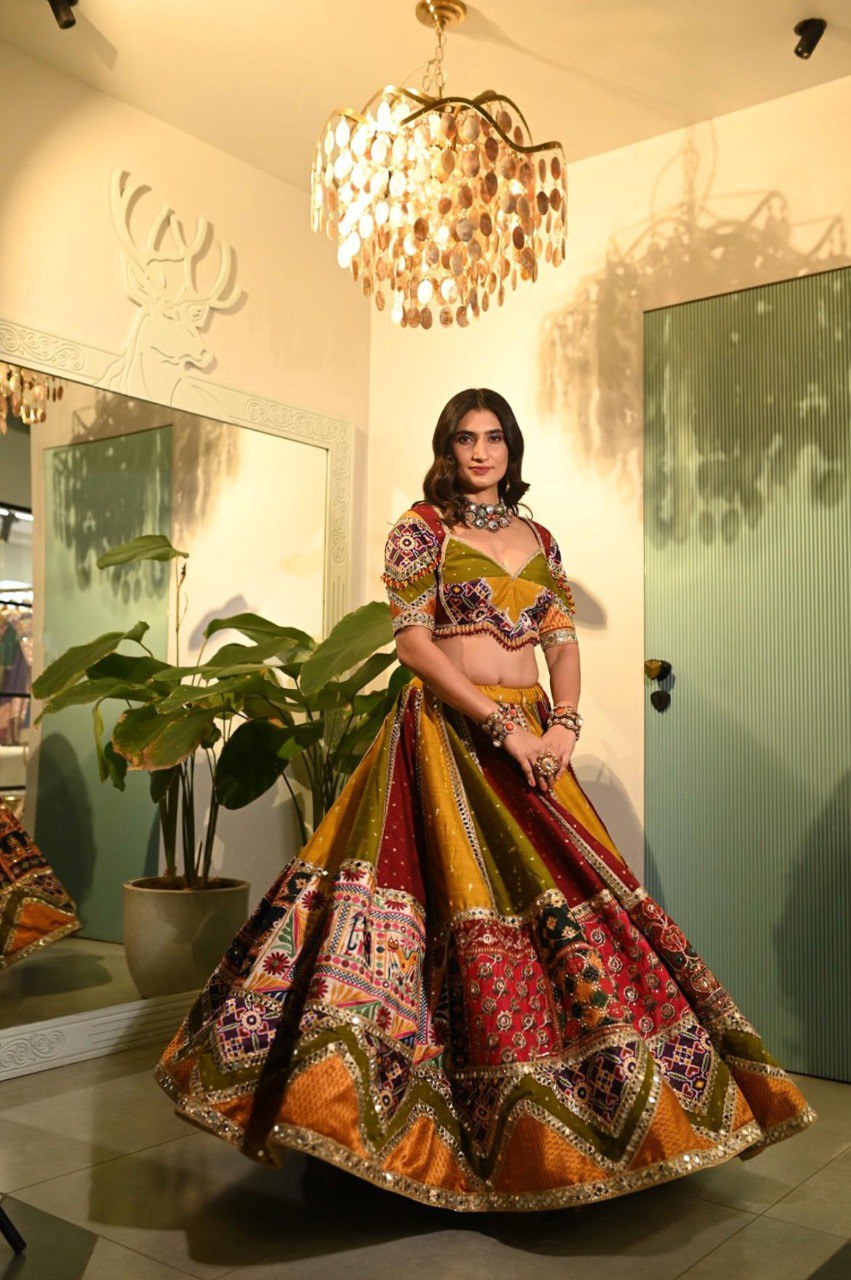 Woman in a vibrant, multi-paneled Navratri Chaniya Choli with a deep neckline blouse, posing gracefully.