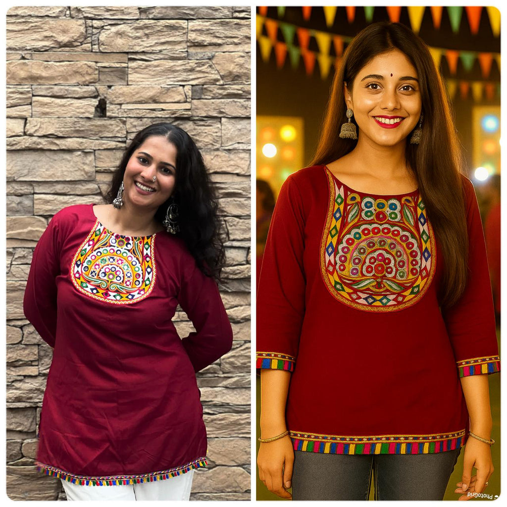 Model wearing a maroon short top with colorful embroidery and tassel hem.