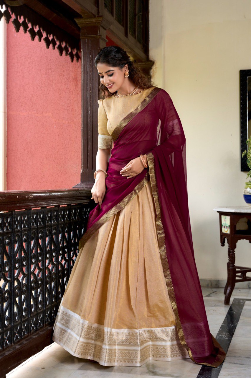 Model wearing a beige Kanchipuram silk lehenga with a maroon dupatta and zari border.