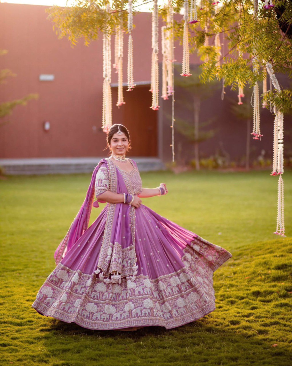 Full shot of a woman wearing a vibrant purple lehenga choli with intricate embroidery and jewelry