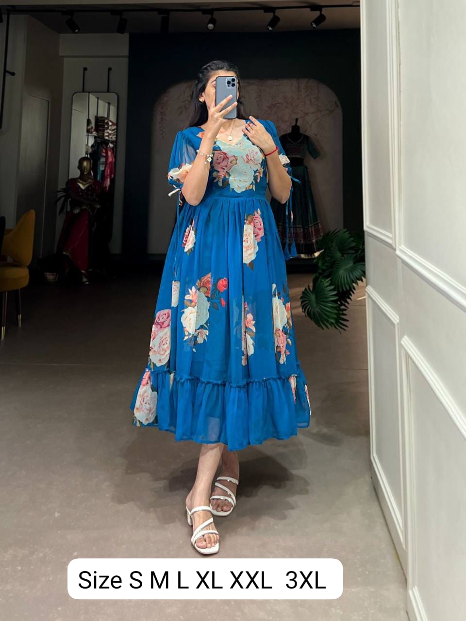 Woman wearing a blue floral maxi dress with trendy sleeves and white sandals