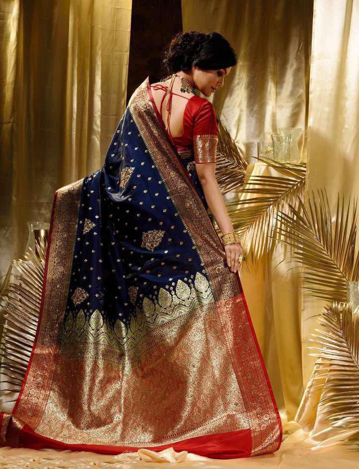 Model wearing a navy blue Lichi silk saree with red border and gold jacquard work.