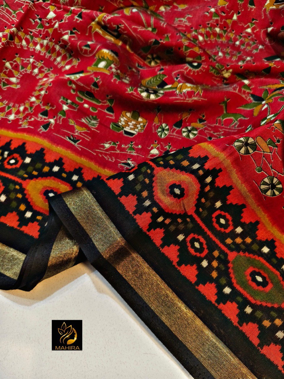 Close-up of a red Katha Silk saree with intricate patterns and a gold zari border.