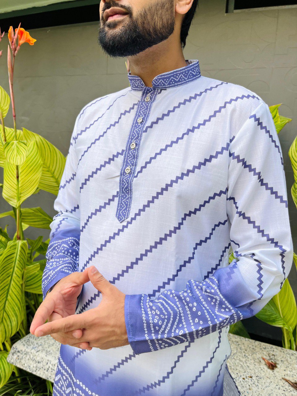 Close-up of a man wearing a white kurta with blue bandhani print, zig-zag pattern on the sleeves and collar.
