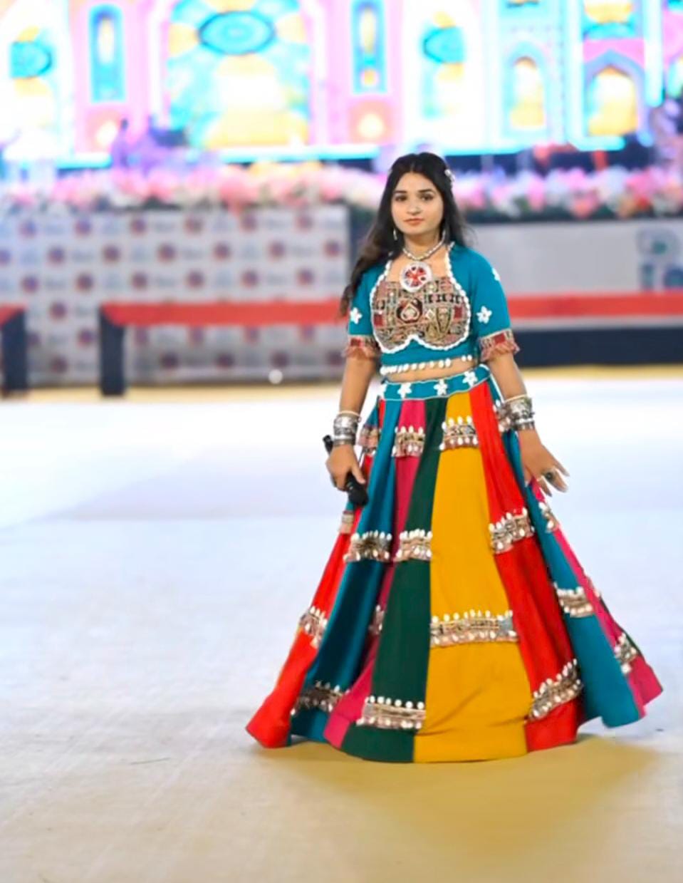 Vibrant Rainbow Kodi Lehenga Choli Set with a model showcasing the full attire during a performance.