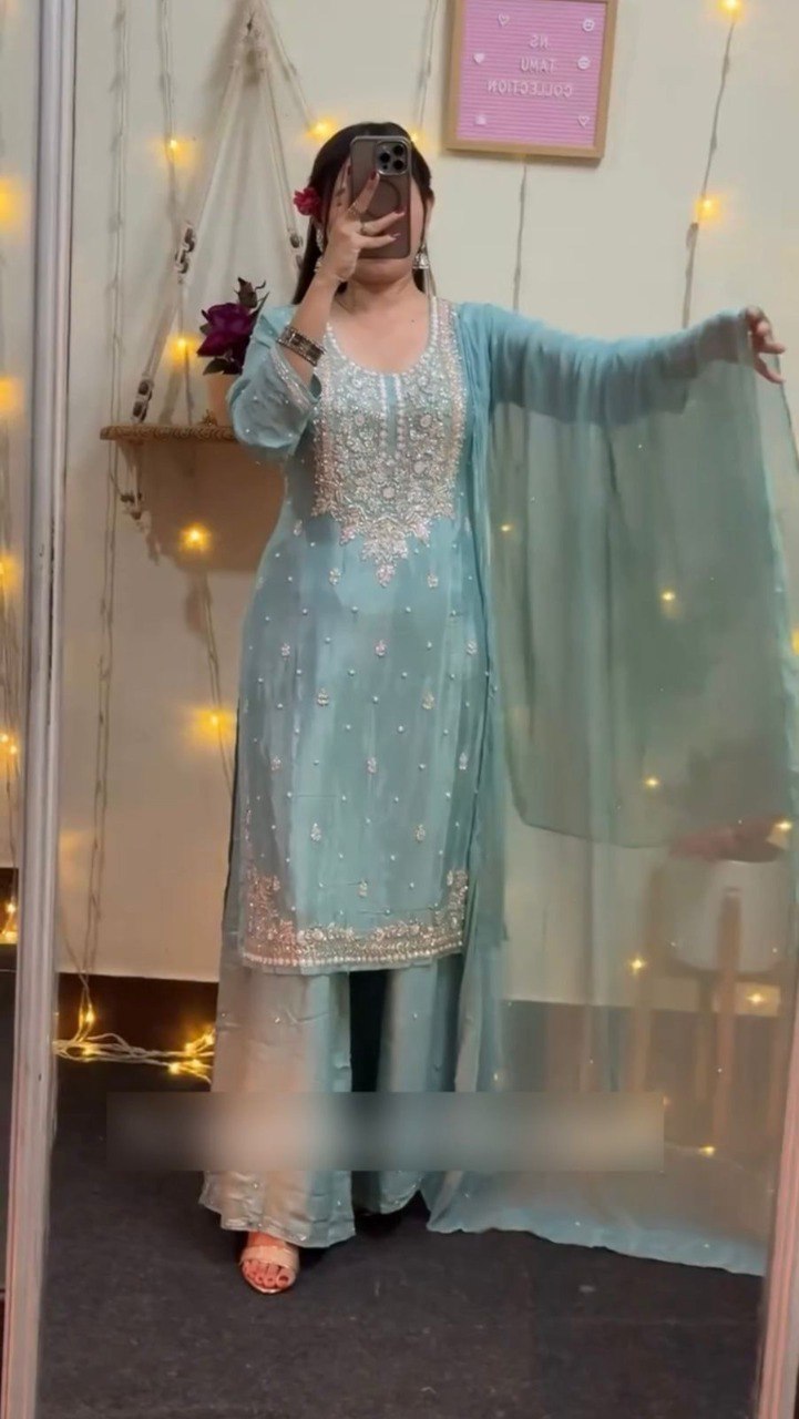 Model in full-length mirror showcasing a mint green faux georgette palazzo suit with heavy silver embroidery and sequin work, holding phone.