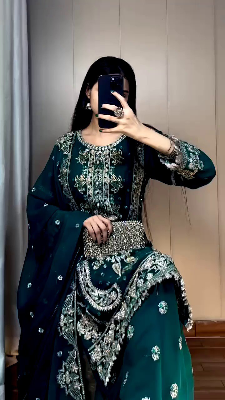 Model showcasing TRENDBUY's emerald green fox georgette sequence embroidery kurta plazzo set, close-up with a clutch.