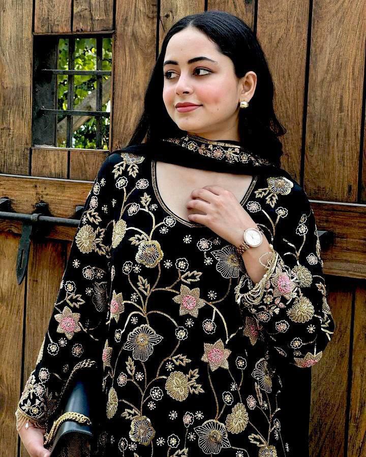 Model wearing a black georgette kurti with heavy floral embroidery, paired with a black dupatta and gold accessories.