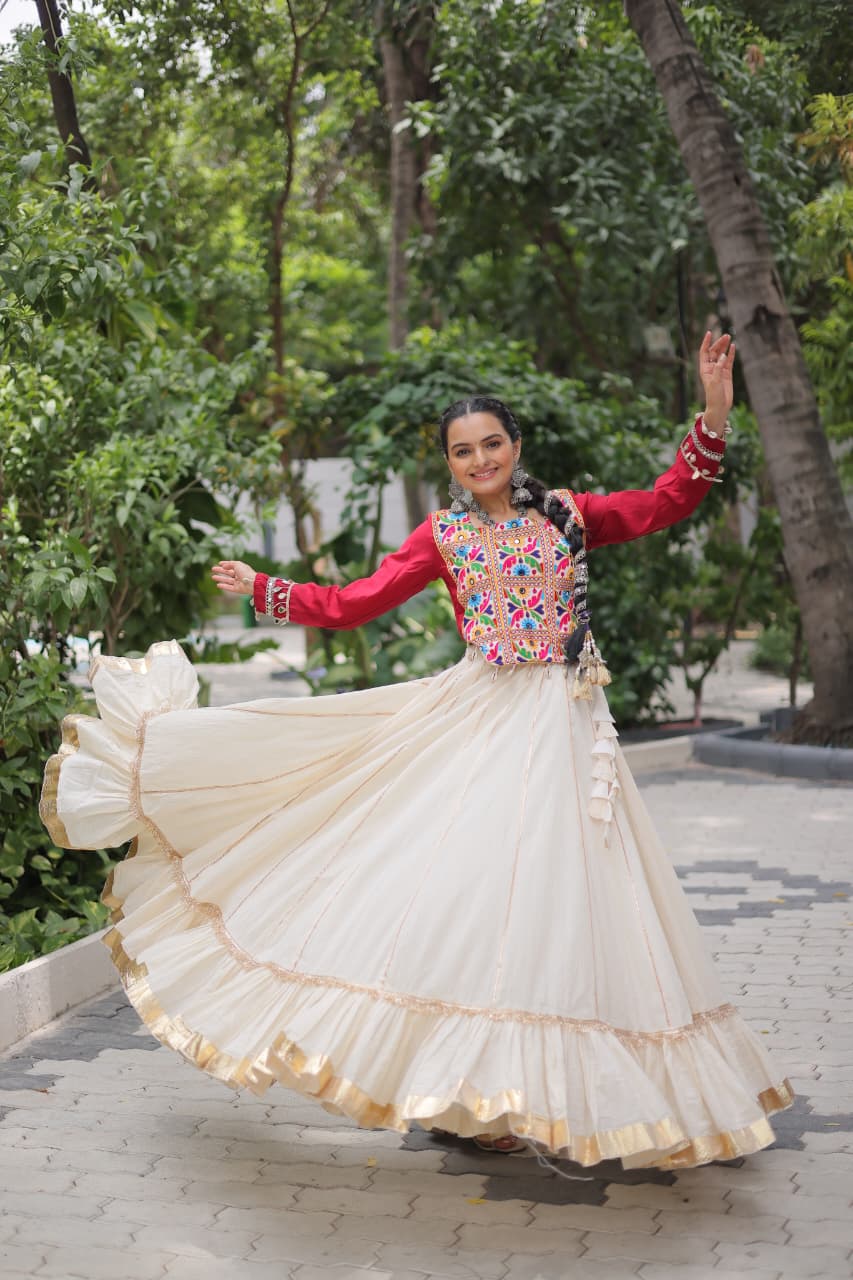 Smiling model twirling in a Kora Cotton lehenga with Gota-Patti lace and a red embroidered Kutchi Gamthi blouse.