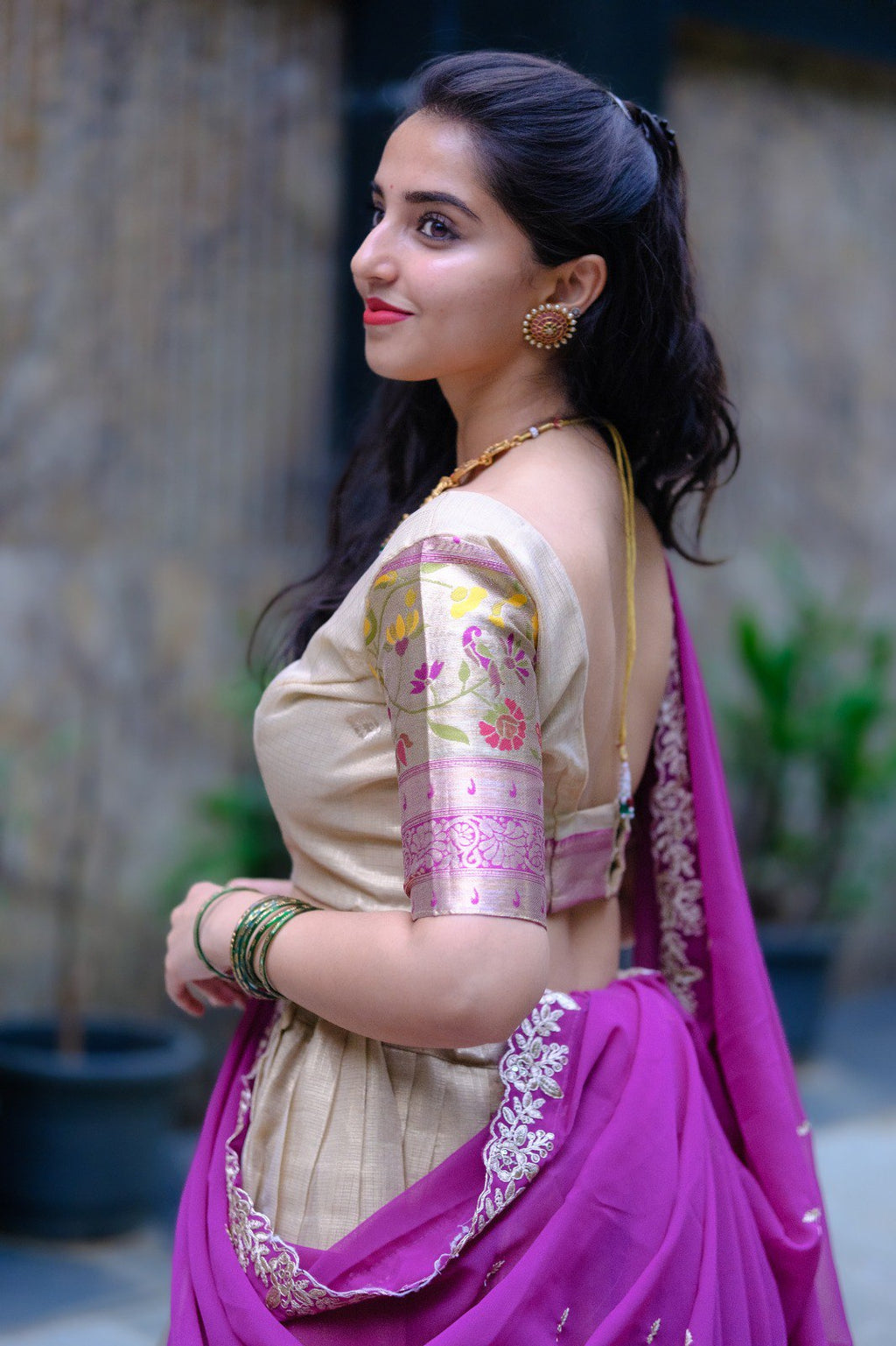 Close-up of a woman's side profile showcasing the intricate Zari Doriya Paithani blouse sleeve embroidery and gold jewelry, part of the TRENDBUY lehenga set.