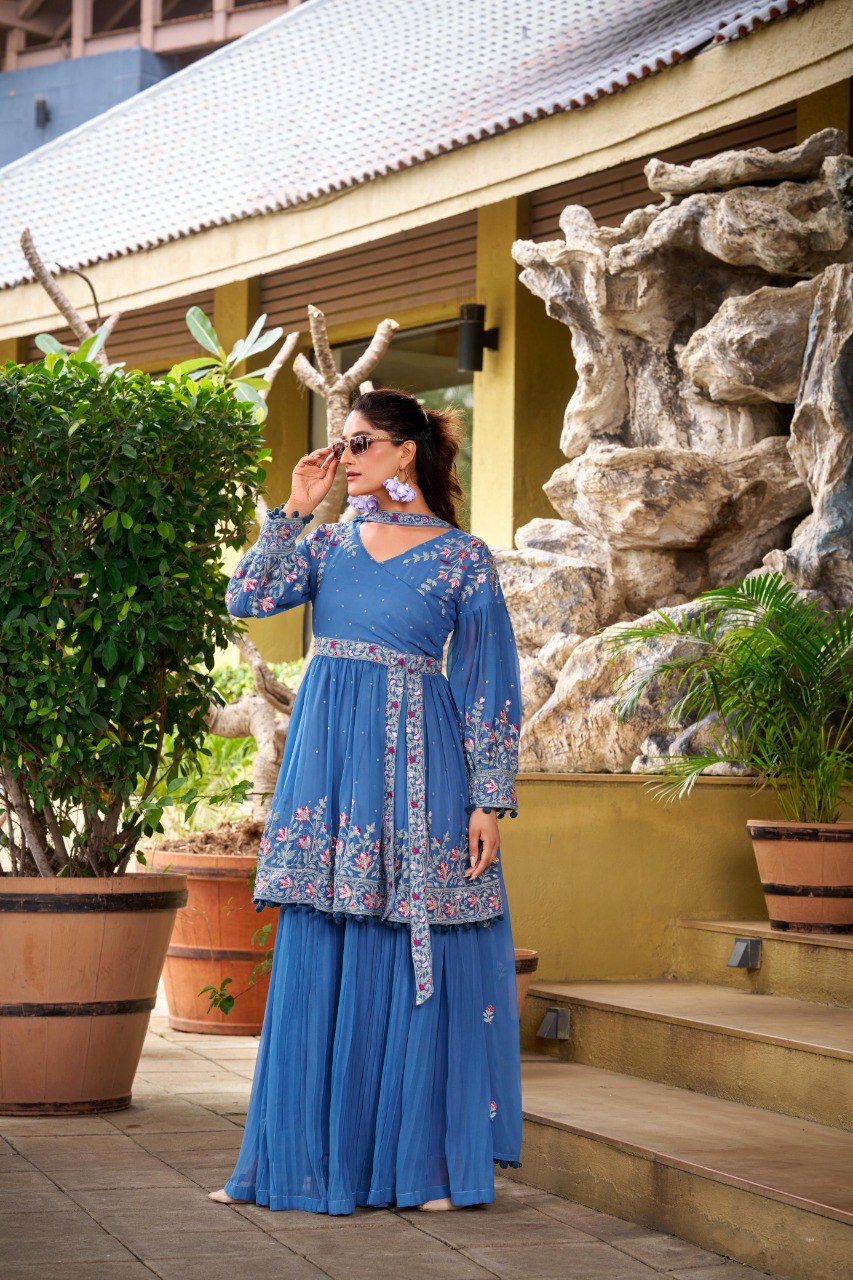 Model in a blue floral embroidered georgette kurti and crushed plazzo set, posing with sunglasses outdoors.