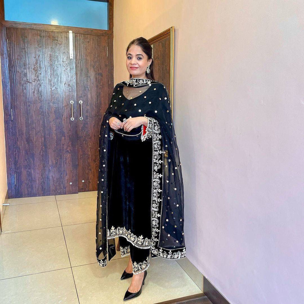 Woman wearing a black designer velvet kurta set with palazzo and embellished dupatta