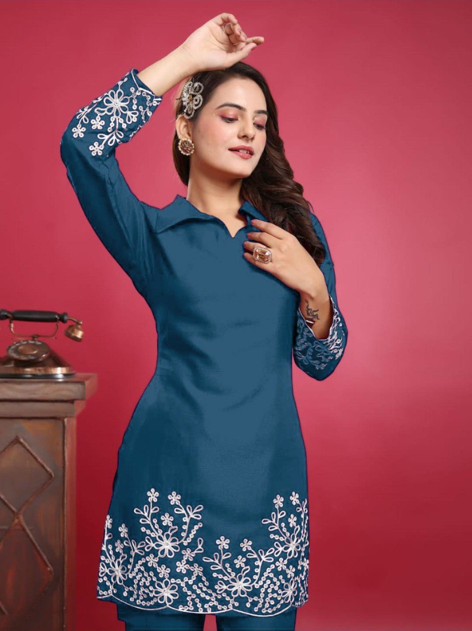 Model posing in teal embroidered slub cotton kurta set, showing sleeve and hem detail.