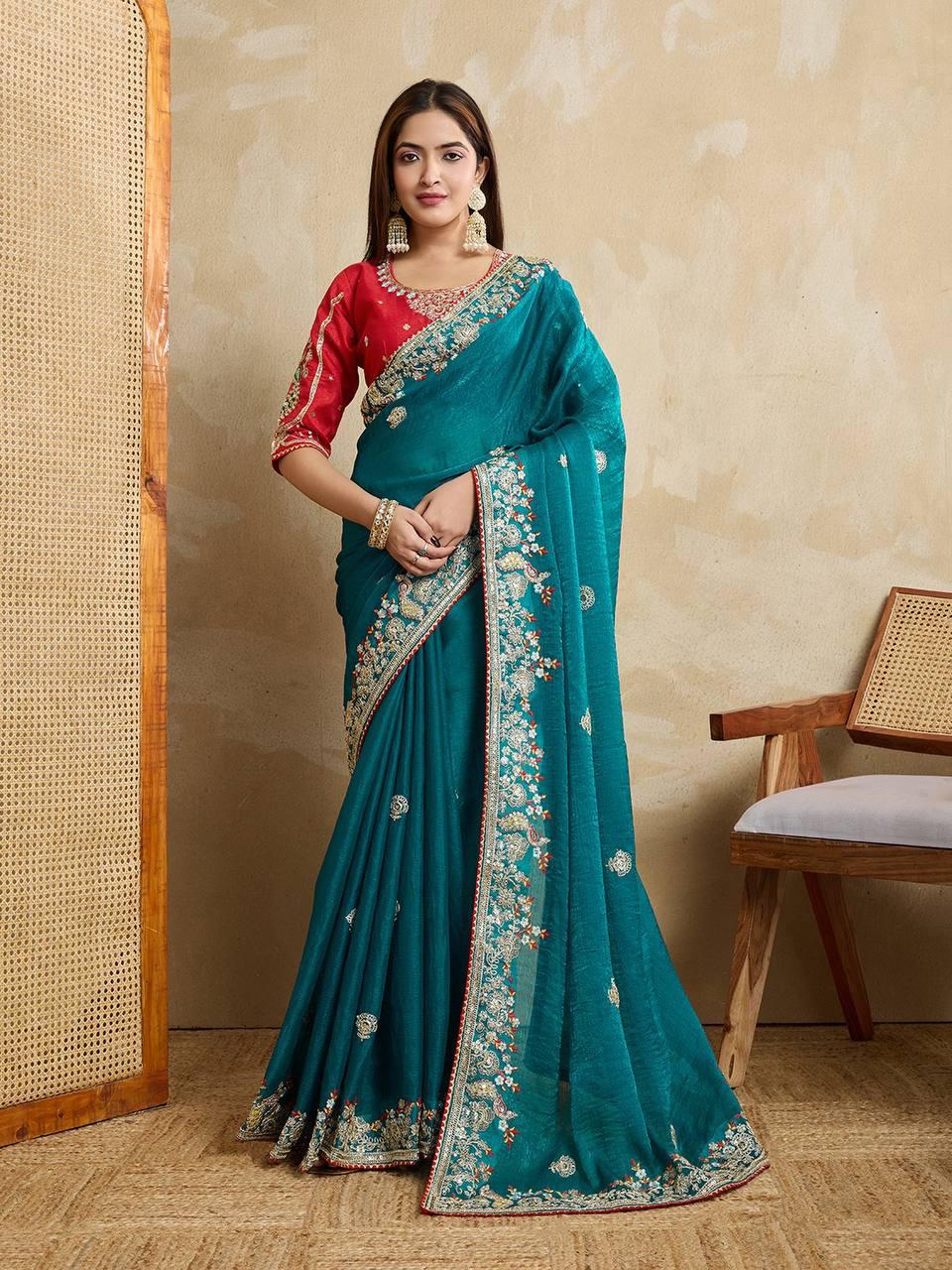 Full shot of model elegantly posing in a Teal Blue Fendy Chiffon silk saree with a red embroidered blouse.