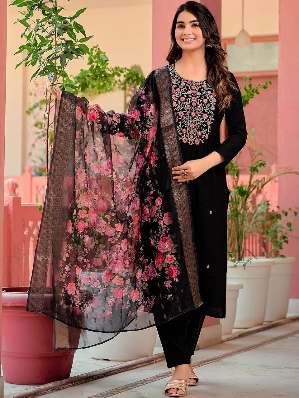 Smiling woman in black embroidered reyon kurta set with floral chanderi dupatta, standing gracefully