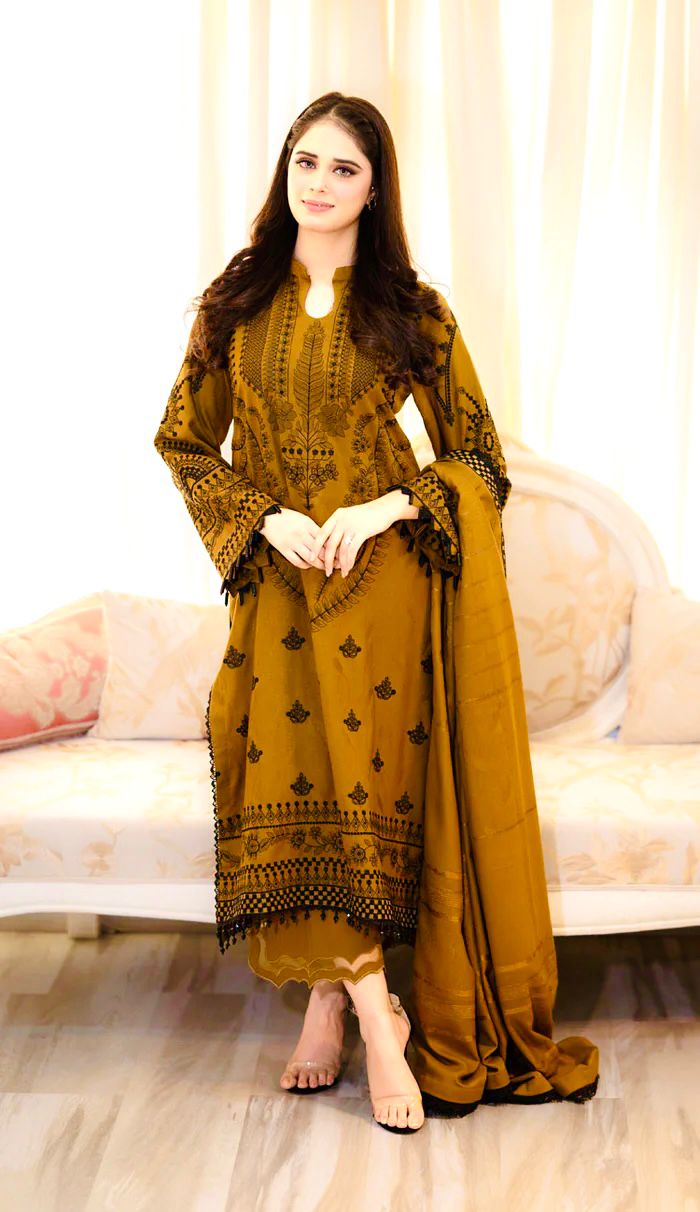 Full length view of a model wearing a mustard yellow designer faux georgette embroidered plazzo suit set.