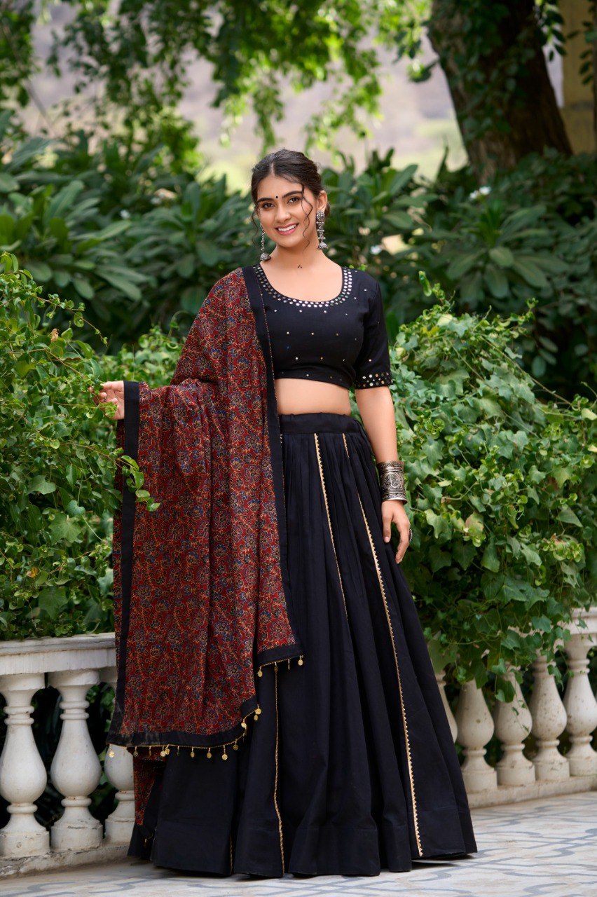 TRENDBUY model in black pure cotton lehenga choli with red patterned dupatta and silver oxidized jewelry, posing outdoors.