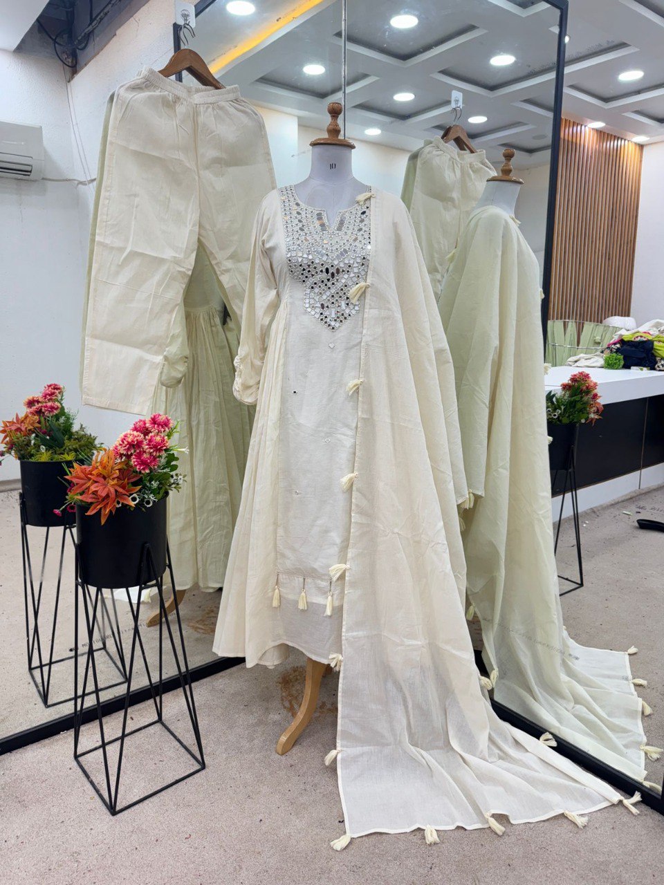 Full view of pristine white Khadi cotton anarkali gown set on mannequin, showcasing mirror work and flowy dupatta.