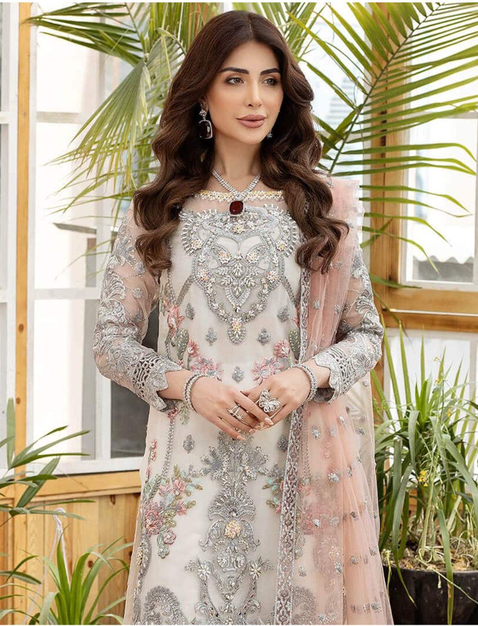 Model in TRENDBUY Pakistani butterfly net semi-stitch suit, close-up view highlighting the detailed silver embroidery, diamond work on the neckline, and the soft peach net dupatta, exuding elegance and traditional charm.