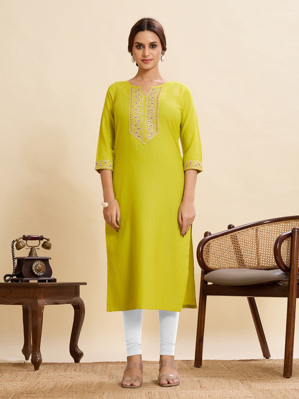 Model in a vibrant lime green cotton kurti with intricate embroidery and sequence work on the V-neck and sleeves.