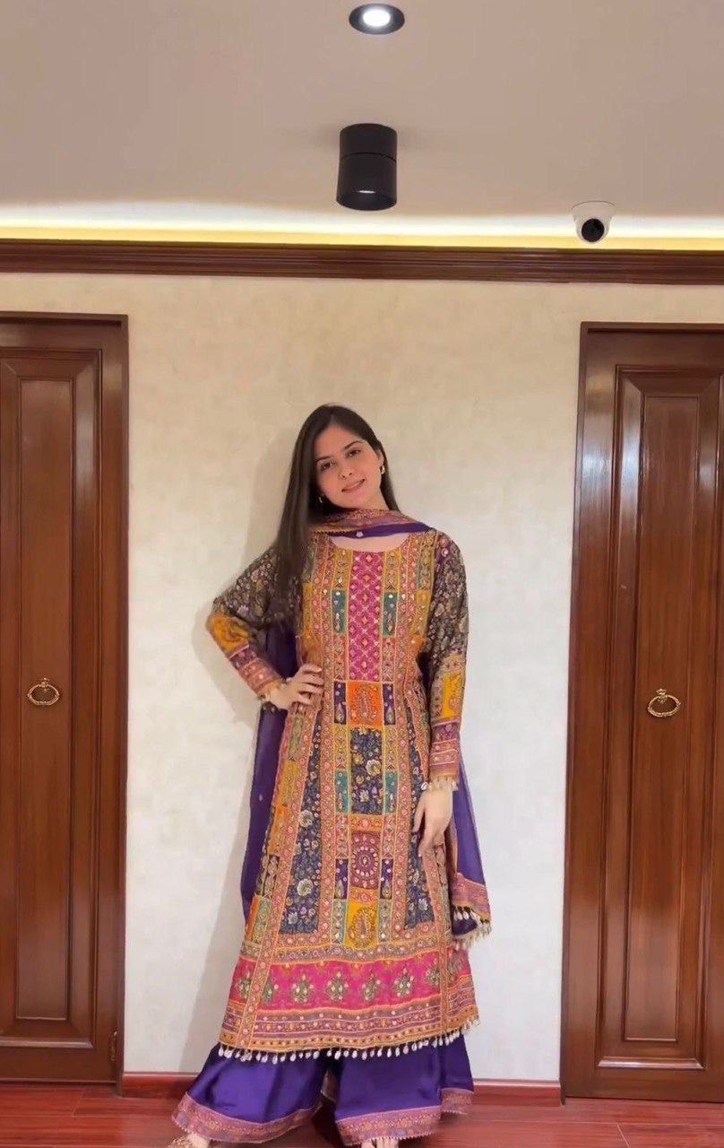 Model in vibrant purple Pakistani suit with elaborate digital print and mirror work, full length shot.