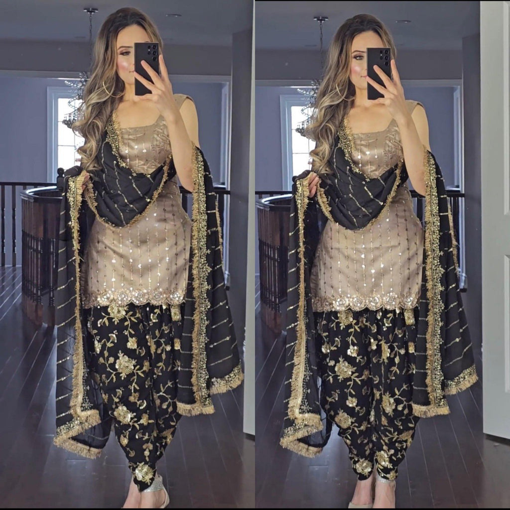 TRENDBUY model showcasing beige top and black dhoti salwar suit with heavy sequence work dupatta.