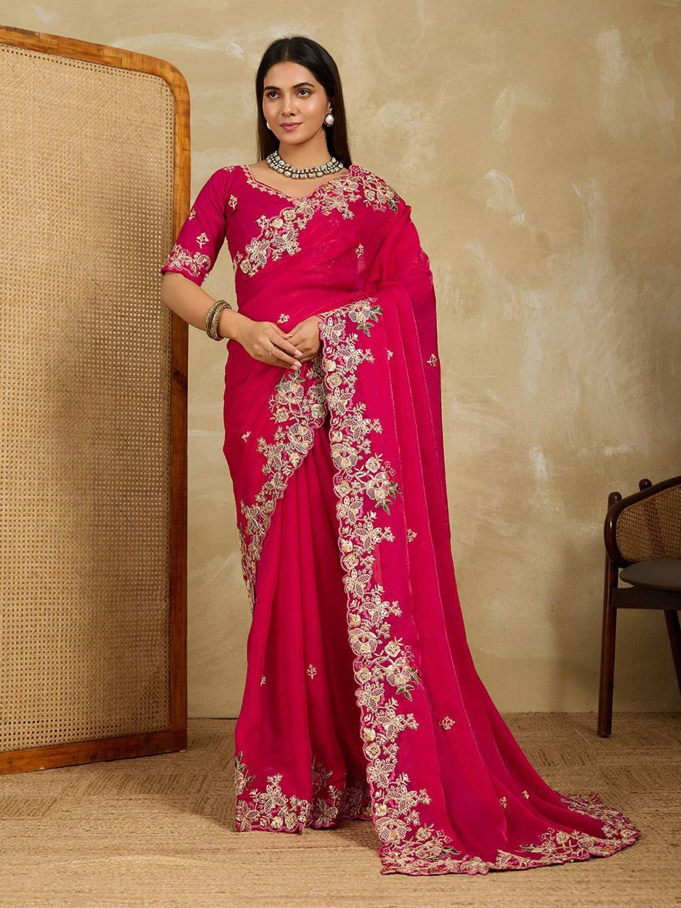 Model in fuchsia pink Fendy chiffon saree with intricate gold embroidery and cutwork border, posing elegantly.