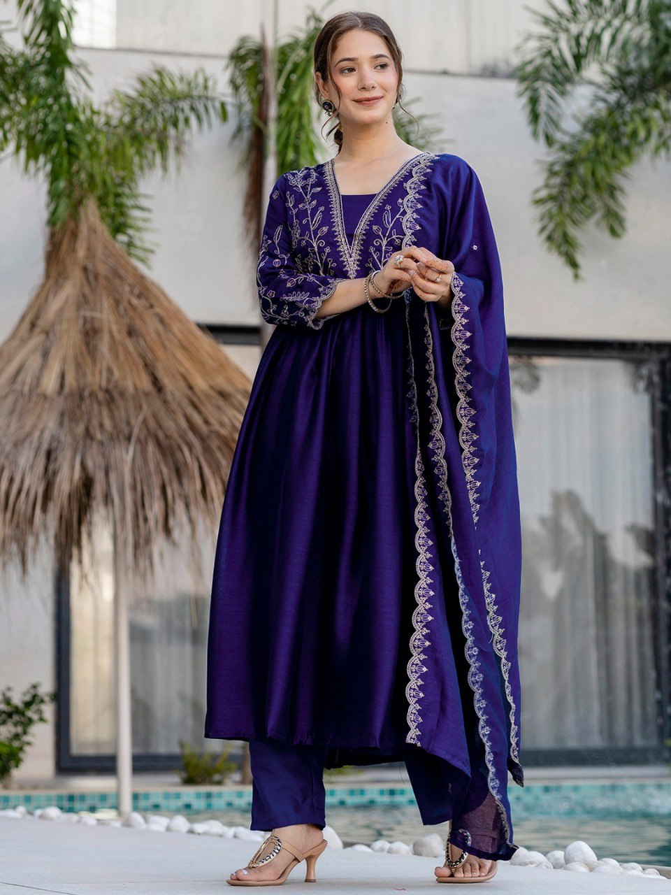 TRENDBUY Blue Vichitra Silk Flared Kurta Set with intricate embroidery, front view, standing by pool.