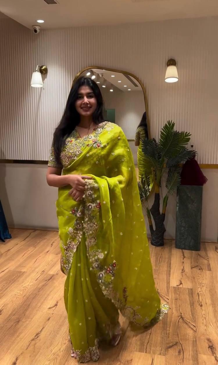 Model smiling in a lime green Zimmy Chu silk saree with intricate floral embroidery and cutwork border, showcasing the full drape.