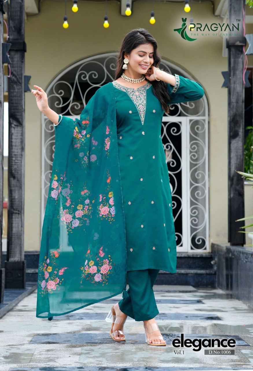 Model in teal Viscose Rayon straight cut kurti set with heavy embroidery and floral digital print dupatta, standing outdoors.