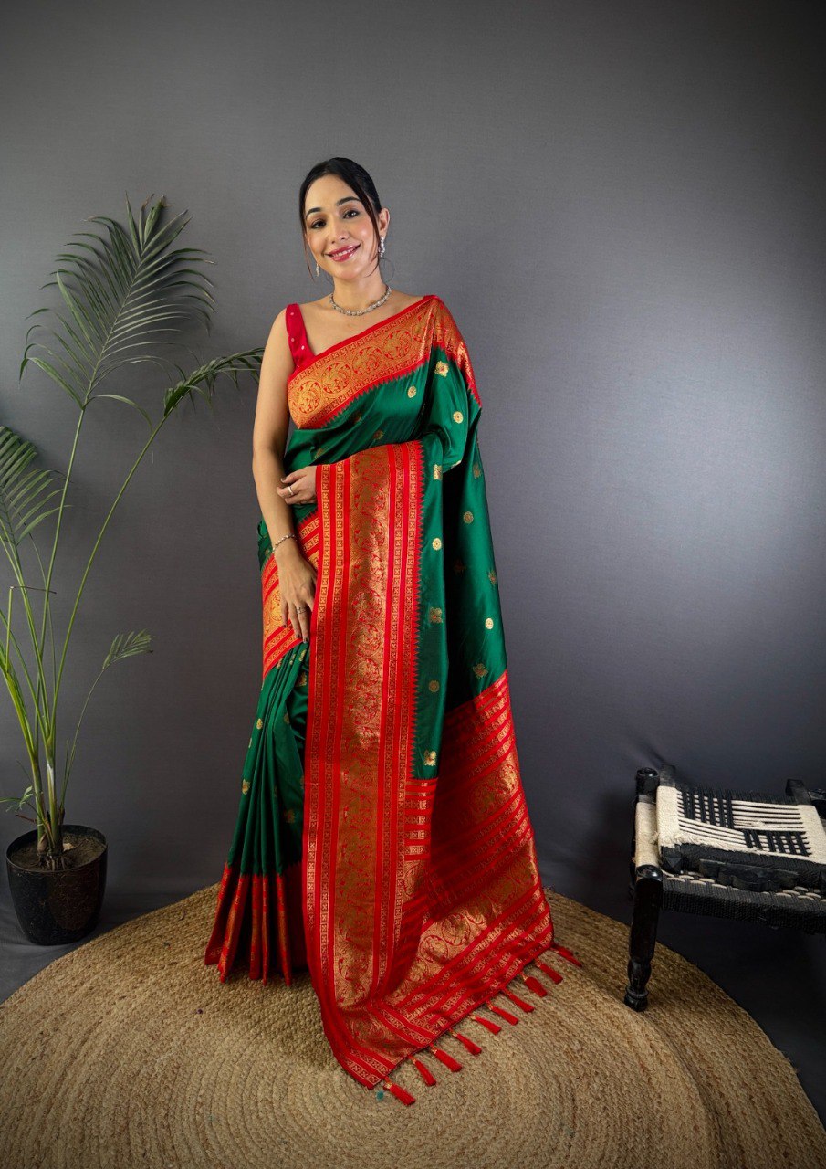 Model in a majestic dark green Maharashtra special soft silk saree with red dual zari border and pallu, standing elegantly.