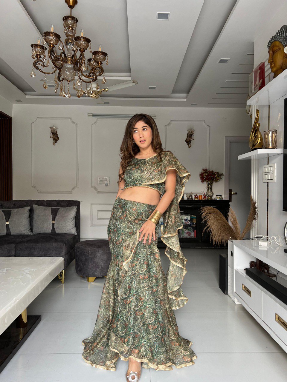 Model posing elegantly in the green sparkle fabric fish cut lehenga choli, showcasing the unique skirt and ruffle details.