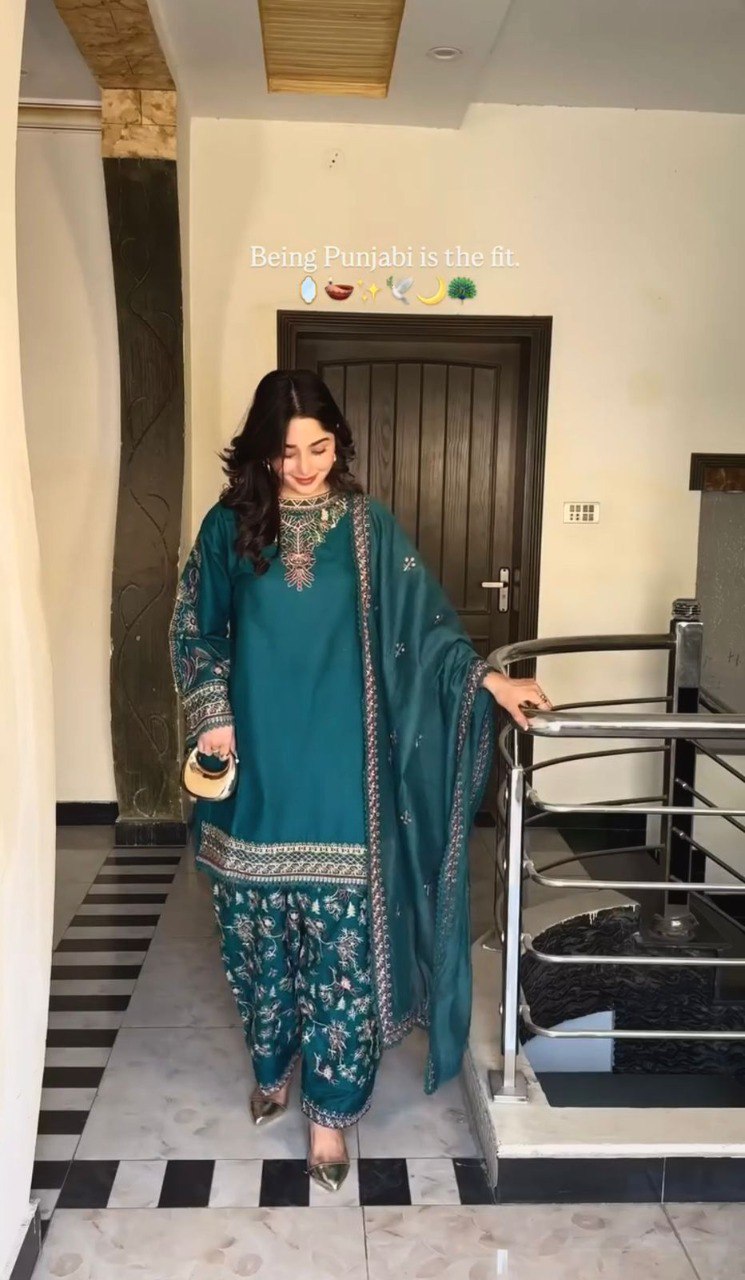 Full shot of model wearing Teal Faux Georgette Dhoti Set with intricate embroidery, walking indoors.
