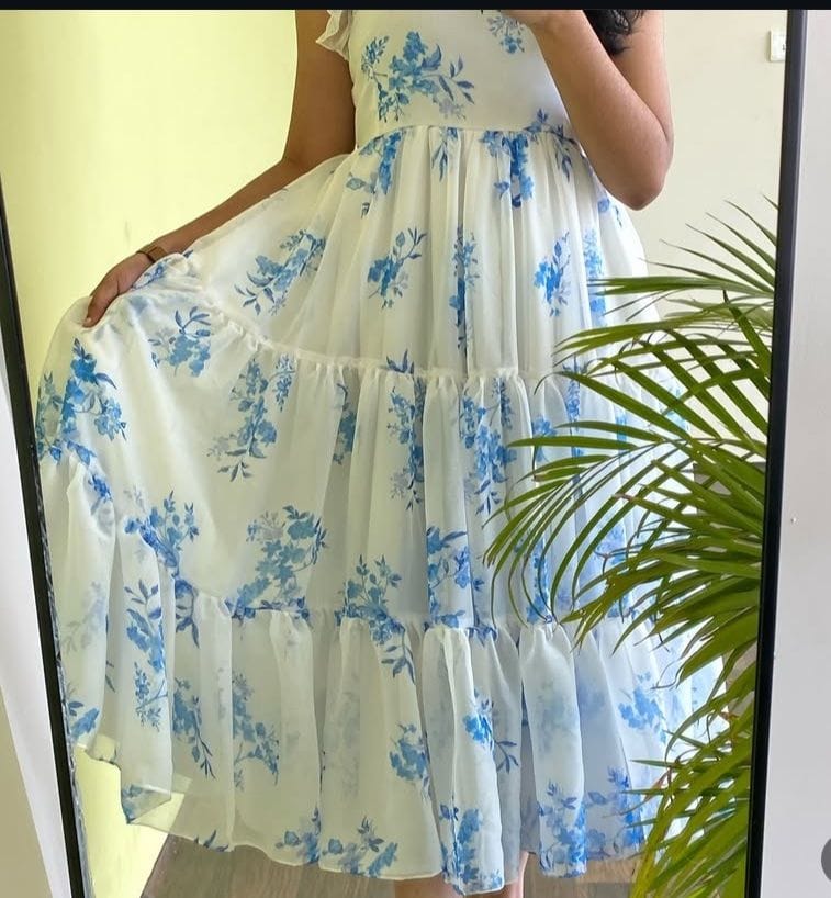 Model showcasing the flowing fabric and beautiful tiered design of the TRENDBUY Vennela white and blue floral print maxi dress in a mirror reflection.