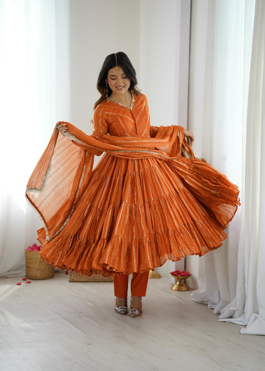 Model in orange Mal Chanderi ruffle gown, twirling to showcase the huge 12-meter flair.