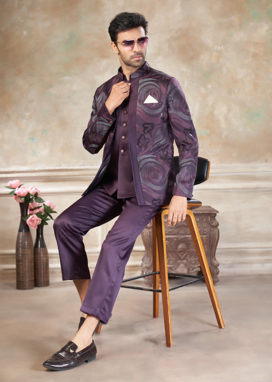 Man in purple designer Jodhpuri suit with intricate embroidery and sequence work, sitting on a chair, showcasing modern ethnic style.
