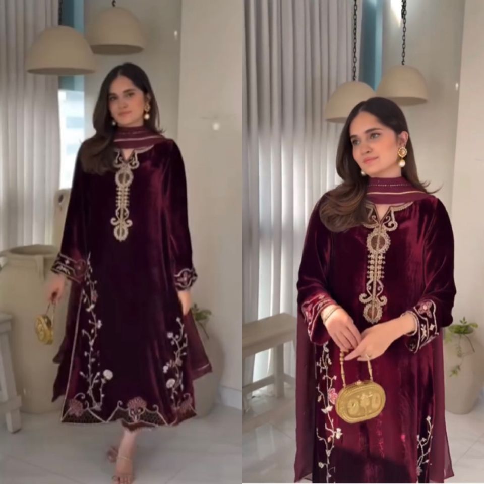 Model in TRENDBUY maroon velvet kurti set, full shot, featuring intricate gold embroidery.