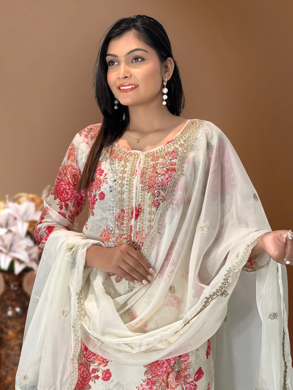 Close-up of model in white Kundan Organza suit, showcasing intricate neckline embroidery with dori, sequence, and mirror work, paired with a floral digital print.